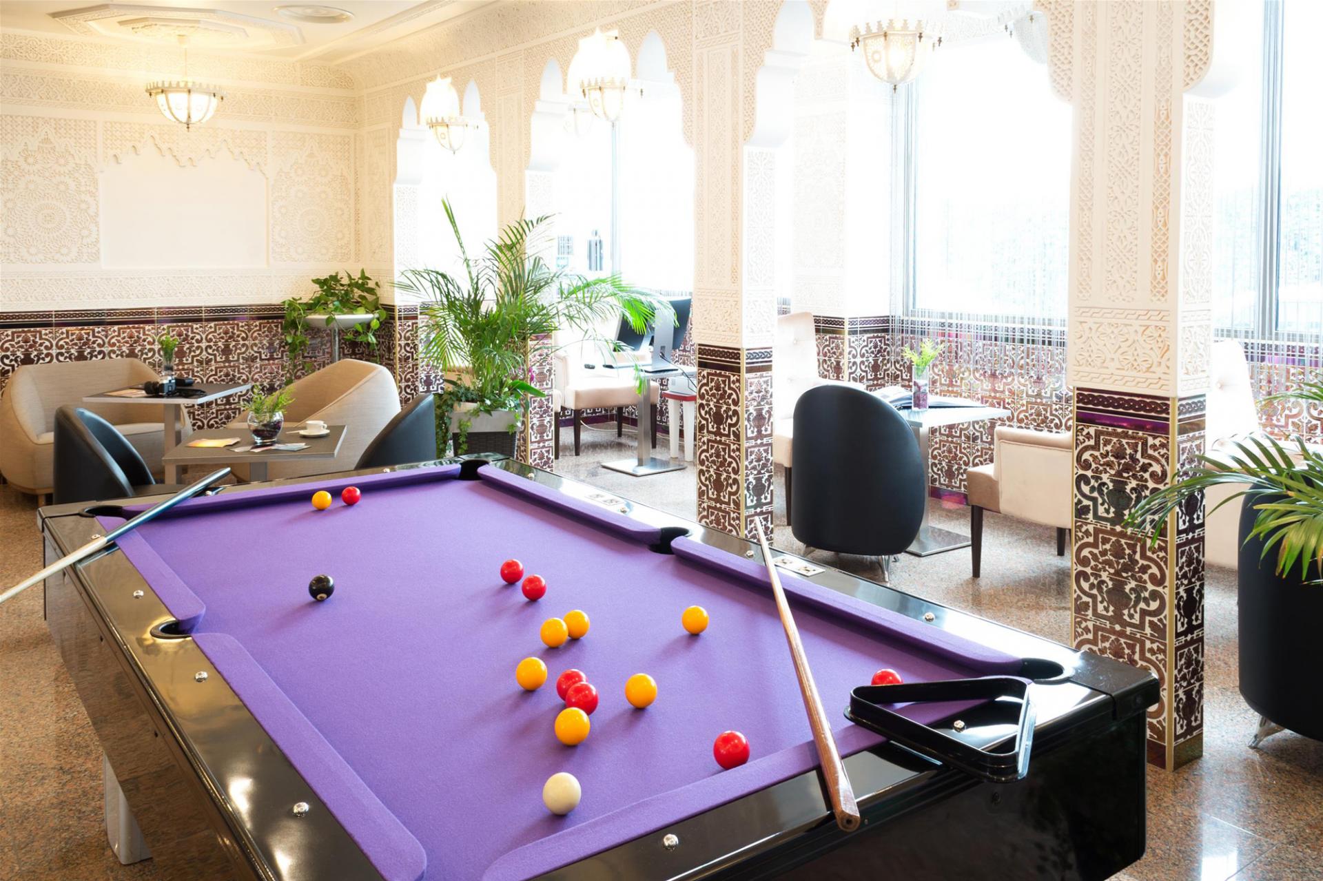 Salon lounge de l'hôtel avec baies vitrées et billard