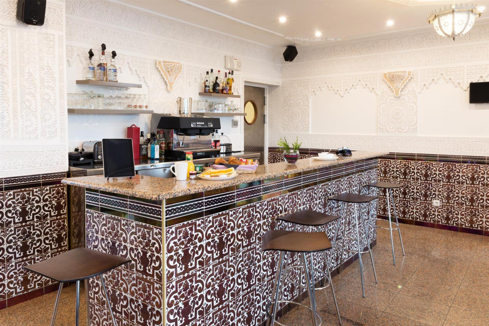 Comptoir du bar de l'hôtel, tabourets hauts et carreaux de faïence