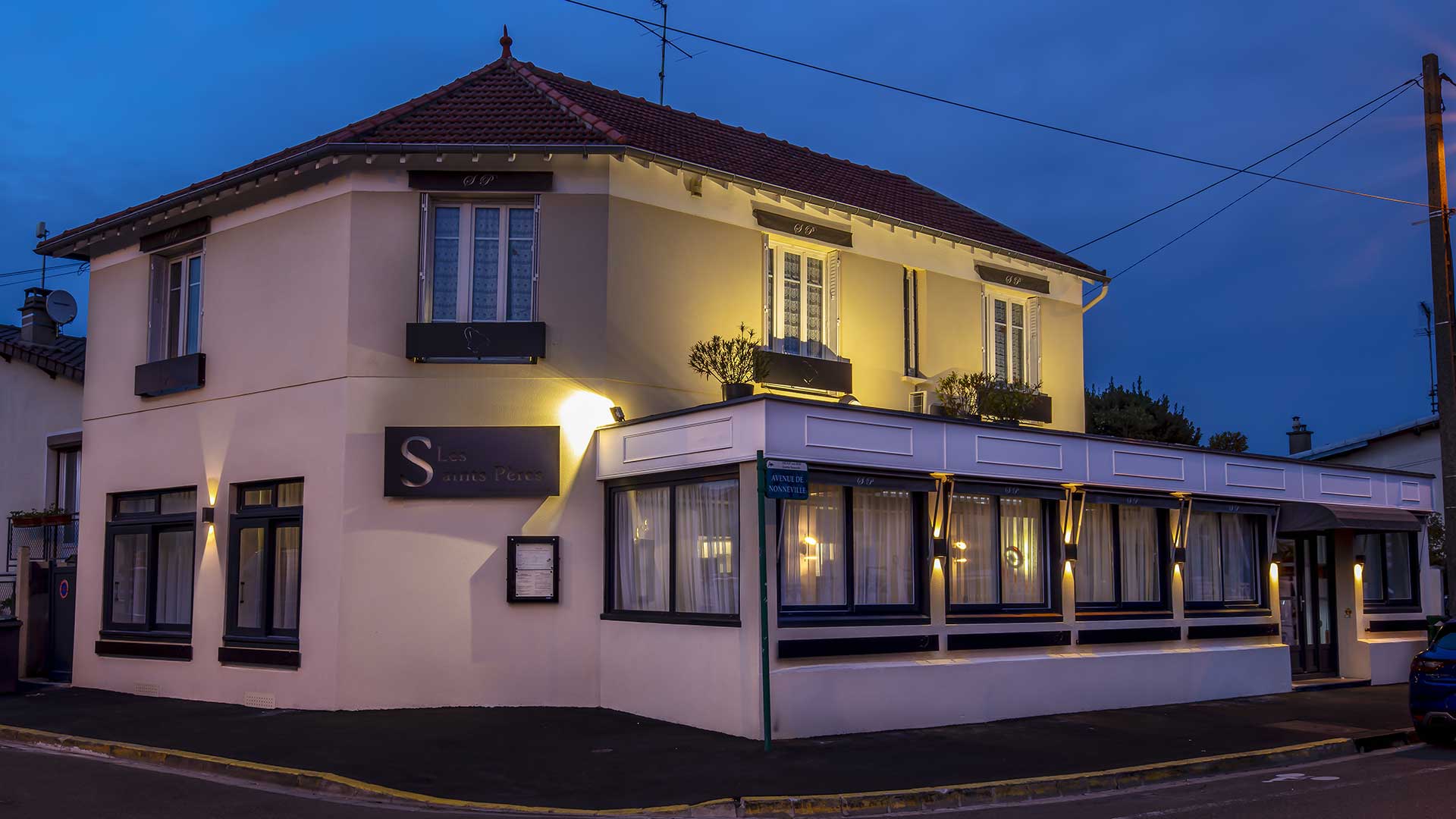 Façade de l'Auberge des Saints Pères à la tombée du jour